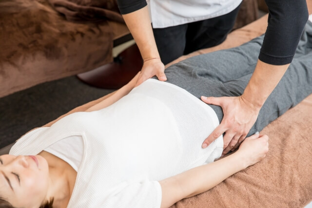 骨盤矯正を受けている患者と施術者の手